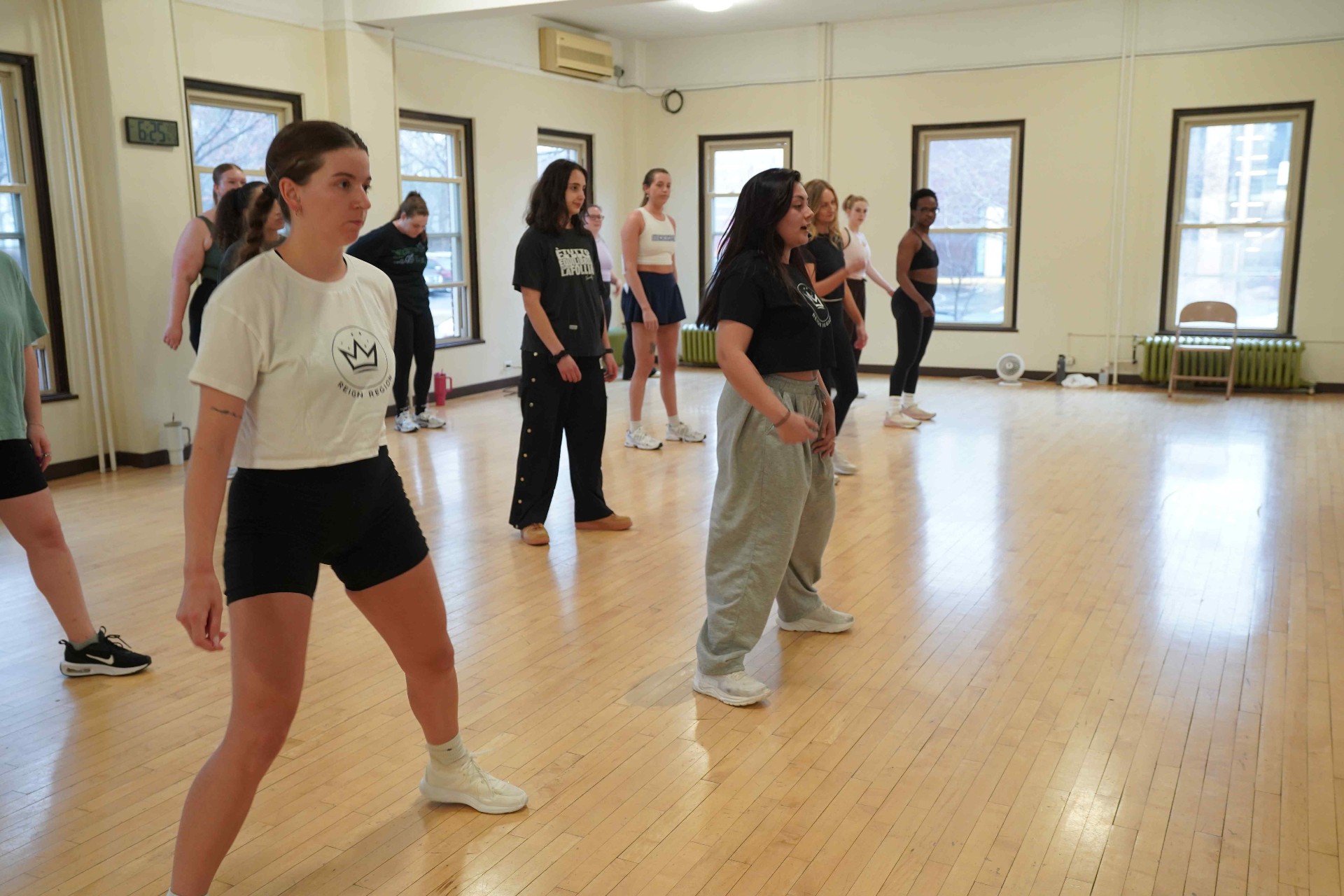 Reign Region dancers in branded crown tees mid-class in the studio