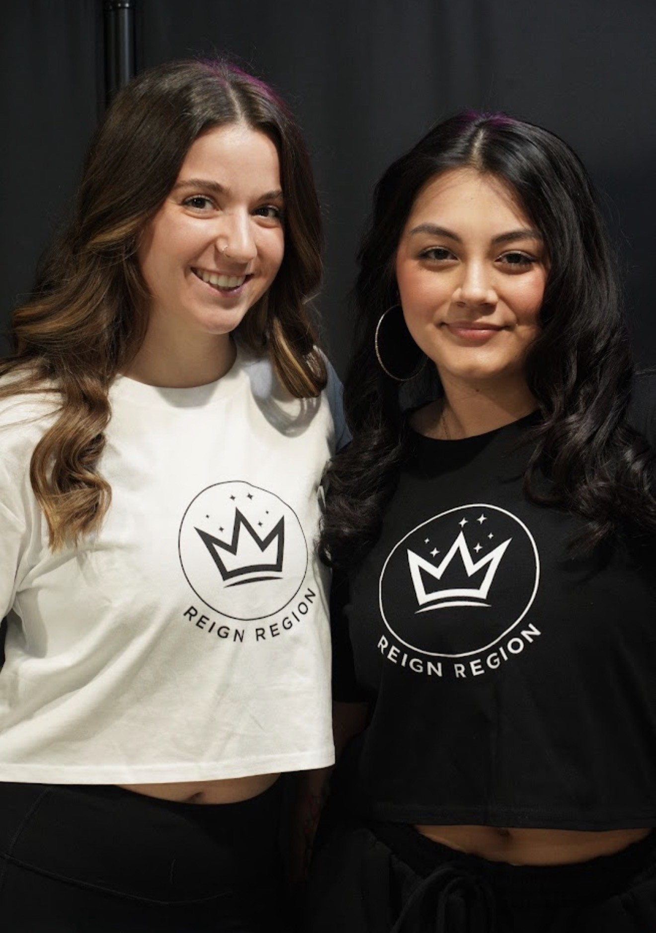 Two Reign Region team members in branded crown tees