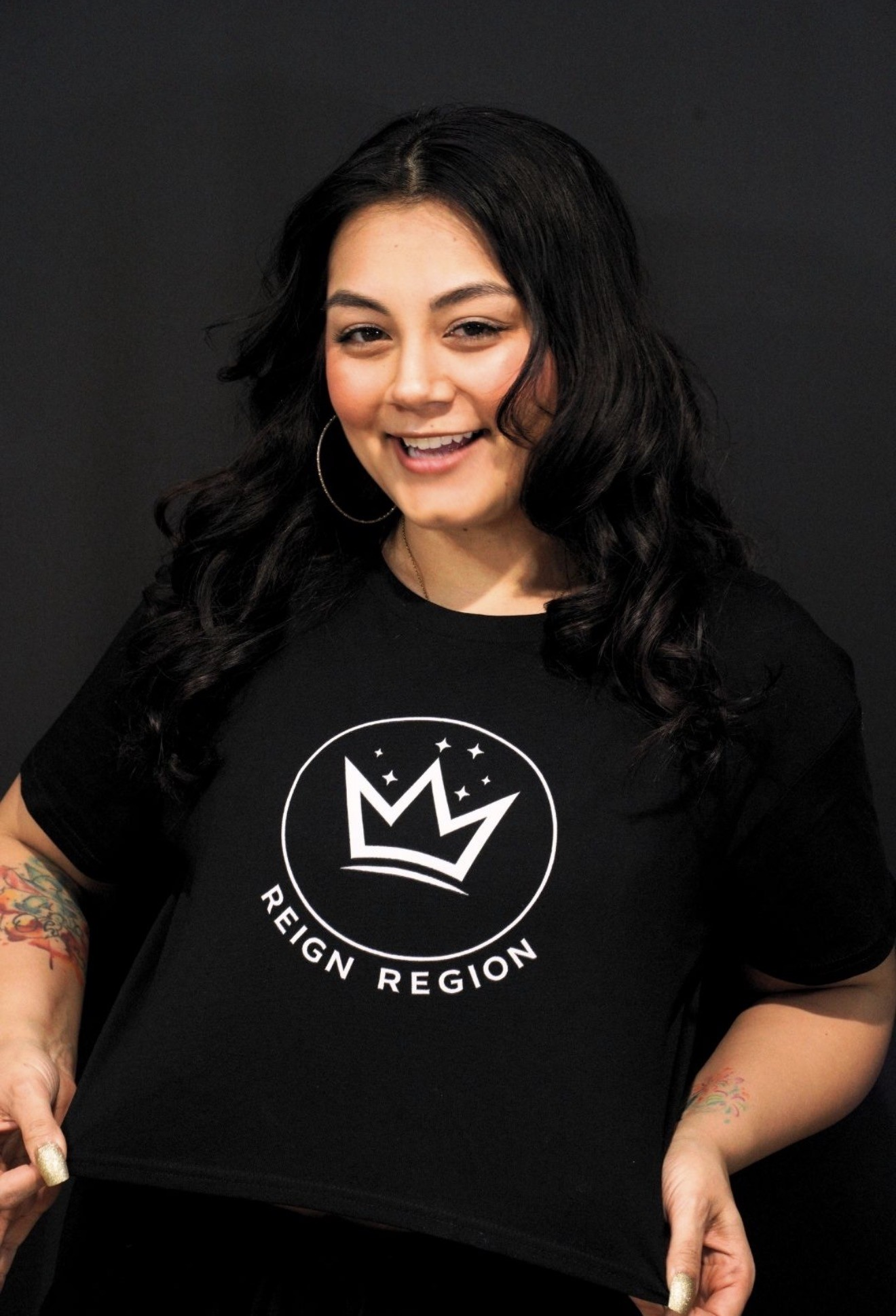 Reign Region team member smiling in a black crown logo tee
